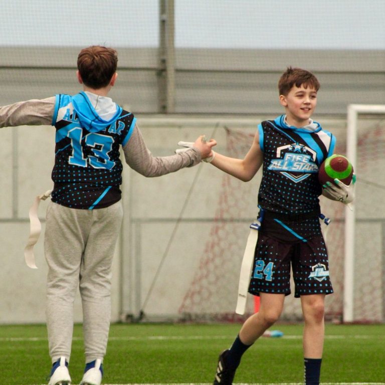 Fife All Stars flag football players high-fiving each other. 