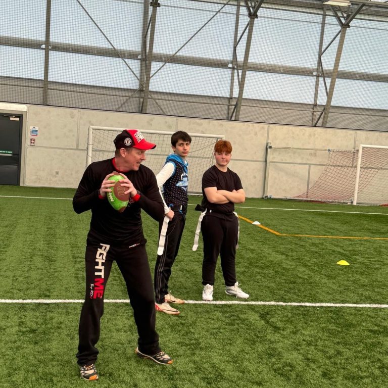 Picture of Quarterback, demonstrating throwing to two Fife All Stars players.