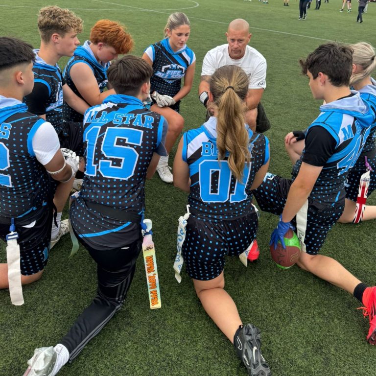 Fife All Stars players, in a huddle, listening to the coach.